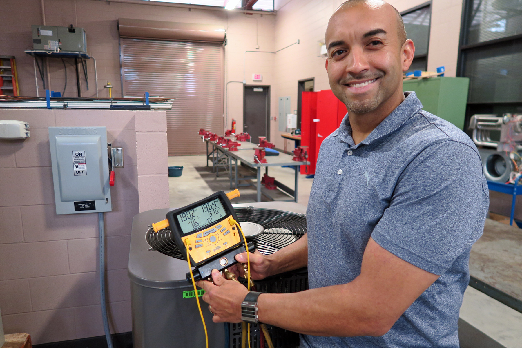 Juan Rivas in HVAC lab holding measurement tool