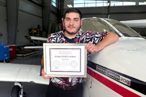 student with certificate by plane