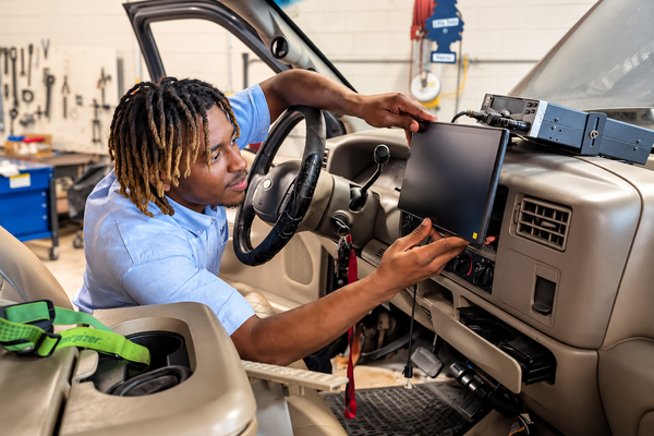Automotive automotive student working on interior of vehicle