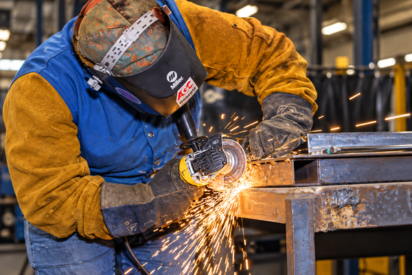 Welding_Metal_Fabrication female welding student grinding metal and sparks flying