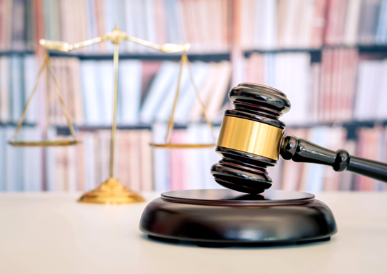 legal Studies: Judge’s gavel and scales of justice displayed in front of law books.
