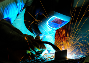 Welding: Welder works on a metal project as bright sparks fly from the welding arc.